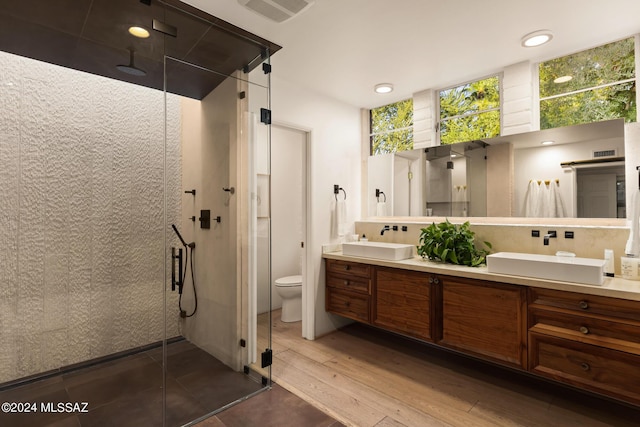 bathroom with an enclosed shower, toilet, decorative backsplash, vanity, and hardwood / wood-style flooring