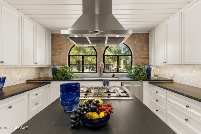 kitchen featuring appliances with stainless steel finishes, island range hood, white cabinetry, and sink