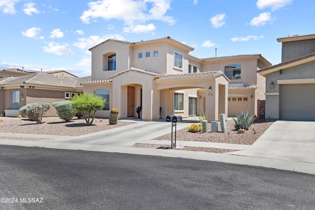 mediterranean / spanish house featuring a tile roof, stucco siding, concrete driveway, and a garage