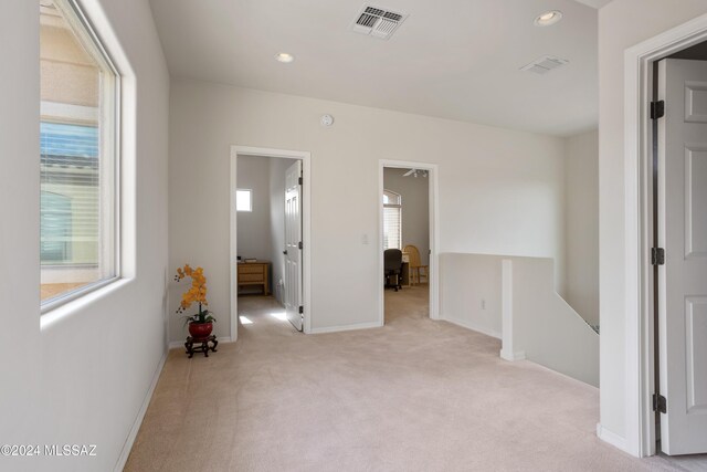 interior space with ensuite bathroom and light carpet