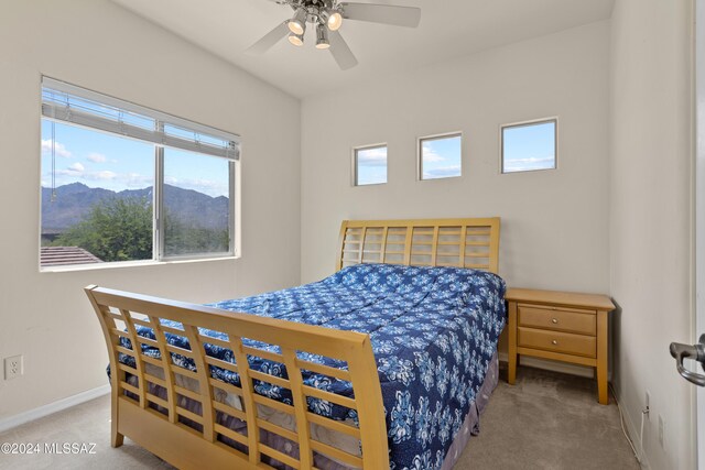 bedroom with a mountain view, carpet, and ceiling fan