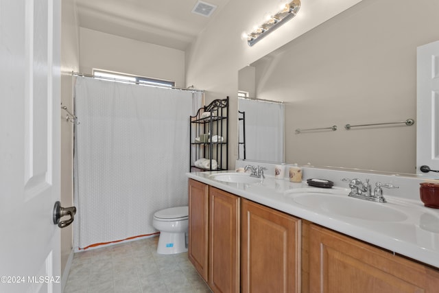 bathroom with double vanity, toilet, visible vents, and a sink