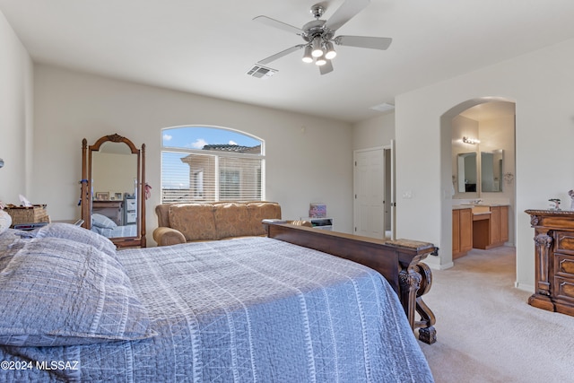 carpeted bedroom featuring ensuite bath and ceiling fan