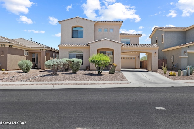 mediterranean / spanish-style house with stucco siding, driveway, and a tiled roof