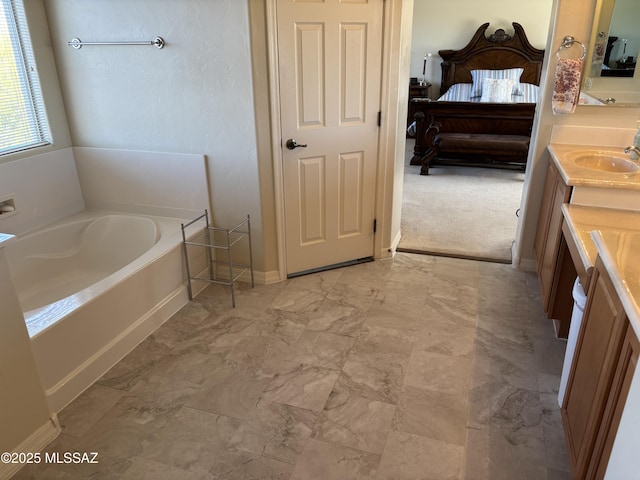 bathroom featuring a garden tub, vanity, and ensuite bathroom