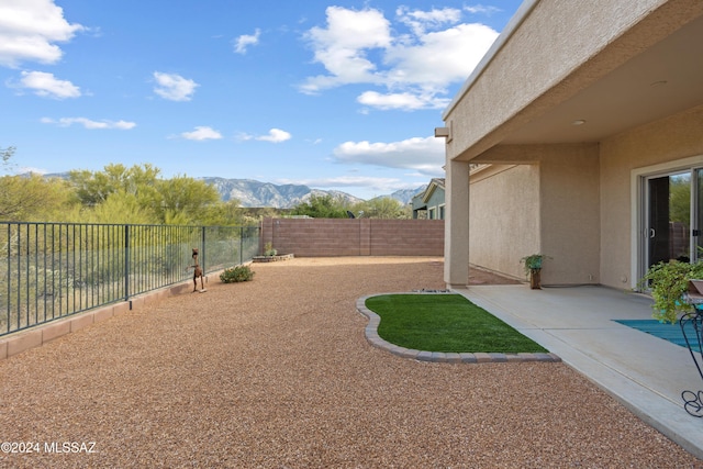 view of yard with a mountain view, a patio, and a fenced backyard