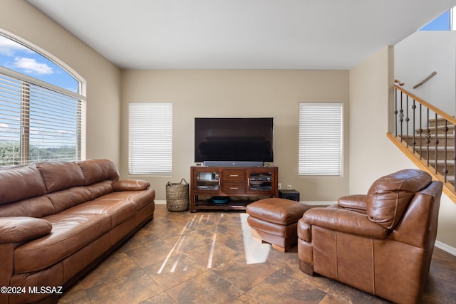 living area featuring baseboards and stairs