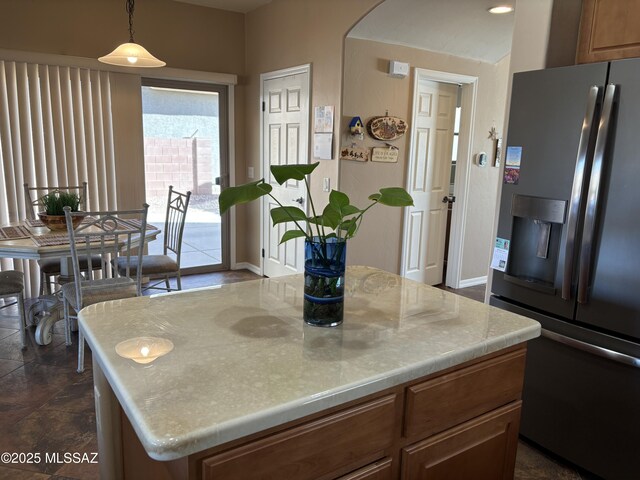 kitchen with pendant lighting, a center island, and white fridge with ice dispenser