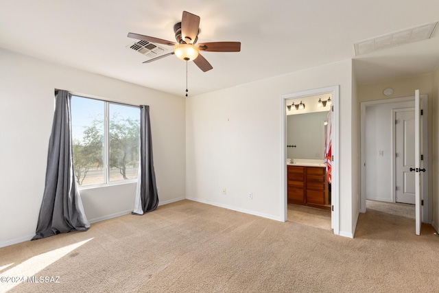 unfurnished bedroom featuring ensuite bathroom, ceiling fan, and light colored carpet