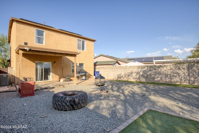 back of property with a patio, central AC unit, and an outdoor fire pit