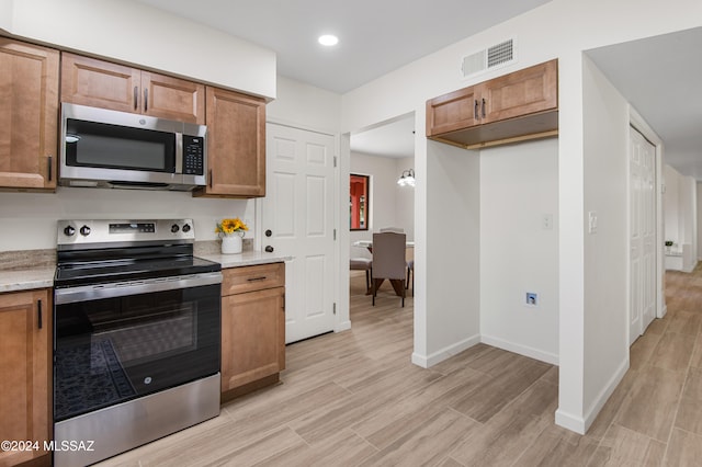 kitchen featuring light stone counters and light wood-type flooring