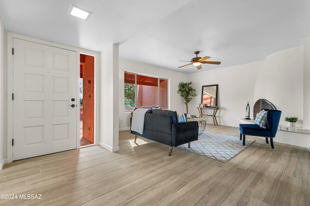 living room with light hardwood / wood-style flooring and ceiling fan