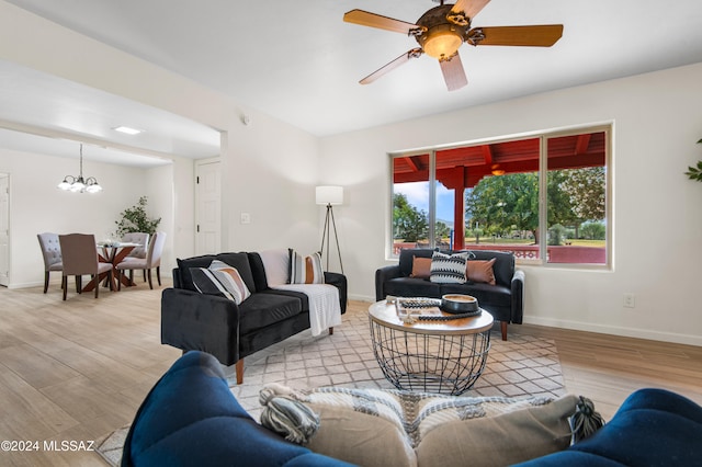 living room with light hardwood / wood-style flooring and ceiling fan with notable chandelier