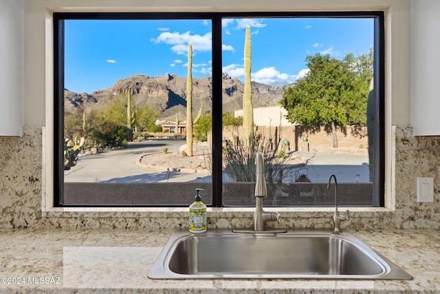 kitchen with a mountain view, tasteful backsplash, and sink