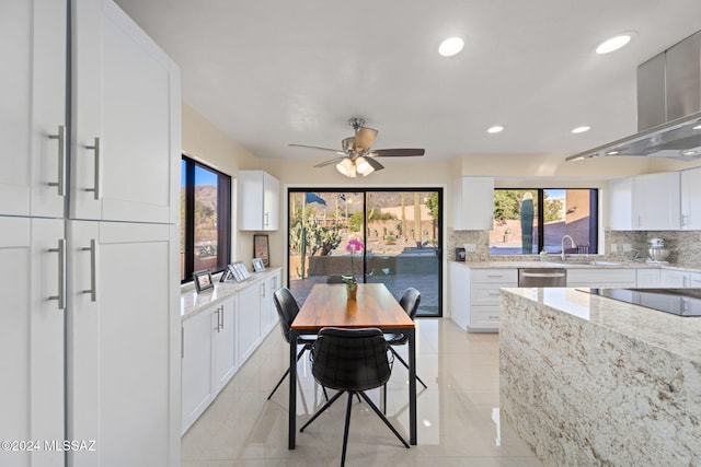 tiled dining area with ceiling fan and sink