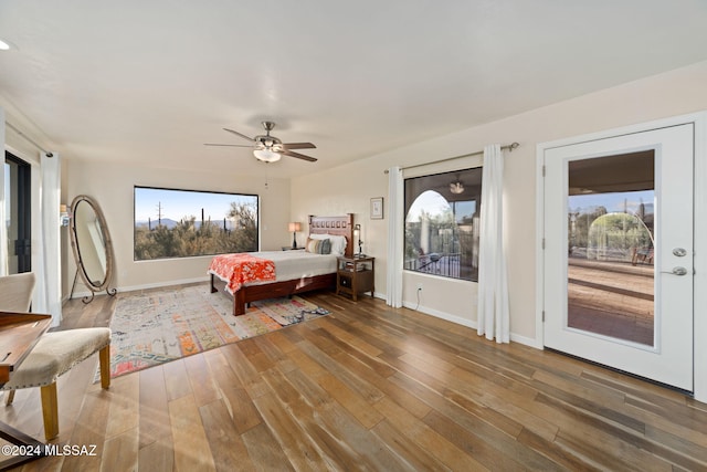 bedroom with access to exterior, wood-type flooring, and ceiling fan