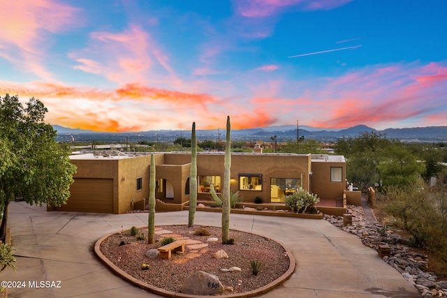 pueblo-style home featuring a mountain view and a garage