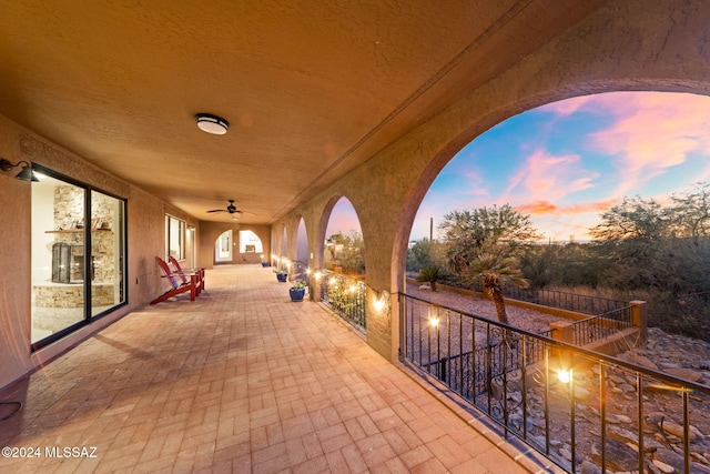 patio terrace at dusk featuring ceiling fan