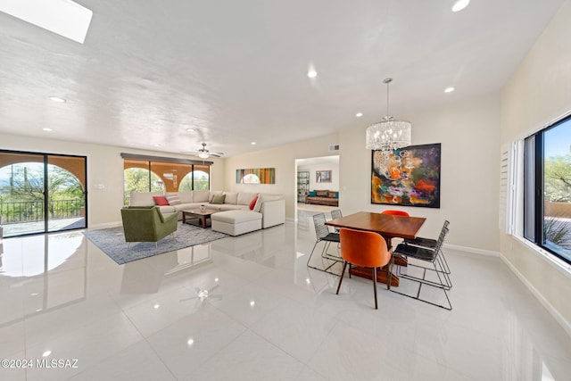 dining space featuring ceiling fan with notable chandelier, light tile patterned flooring, and vaulted ceiling