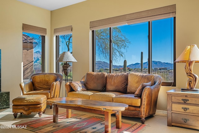 living room featuring a mountain view, light carpet, and a wealth of natural light