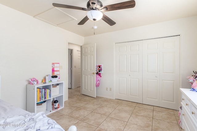 tiled bedroom featuring ceiling fan and a closet