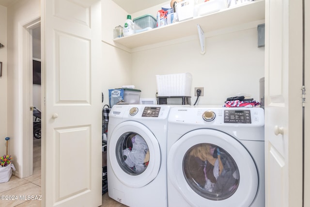 washroom with washing machine and clothes dryer and light tile patterned flooring