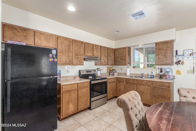 kitchen with black refrigerator, stainless steel electric range, sink, and light tile patterned floors