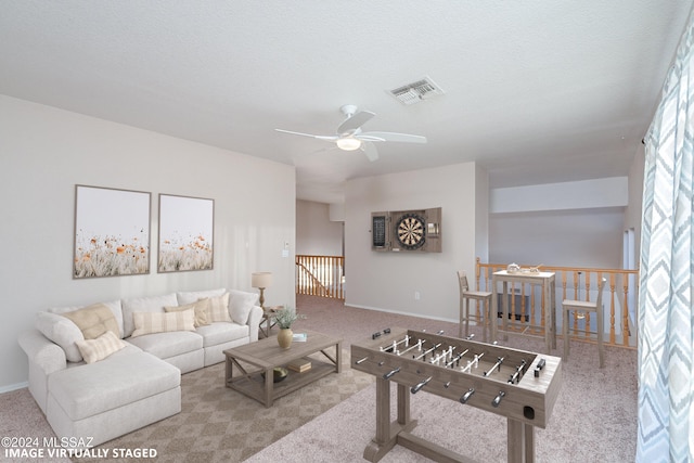 living room with ceiling fan, carpet, and a textured ceiling