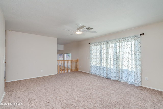 unfurnished room with ceiling fan, light colored carpet, and a textured ceiling