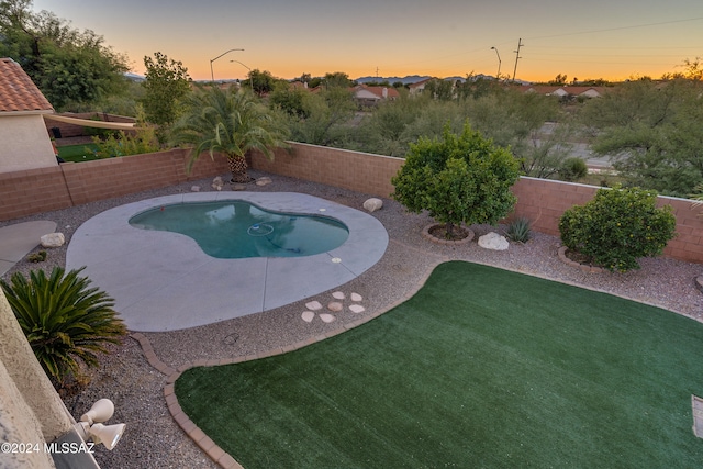 pool at dusk with a patio area