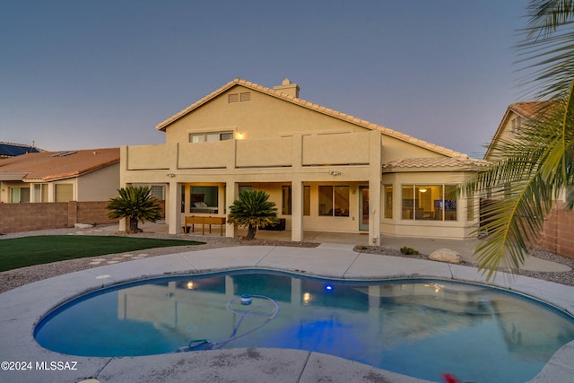 pool at dusk featuring a patio area