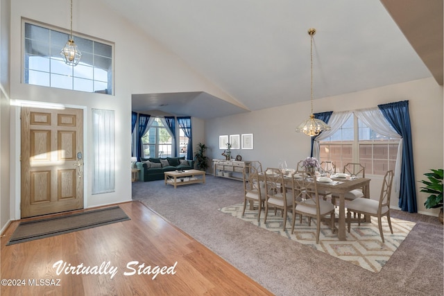 dining room featuring hardwood / wood-style flooring, plenty of natural light, and high vaulted ceiling