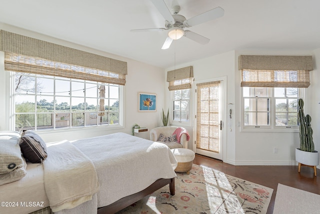 bedroom with ceiling fan, dark hardwood / wood-style floors, multiple windows, and access to outside