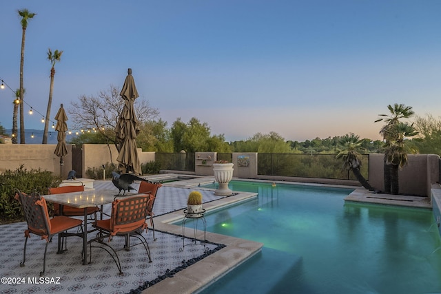 view of pool at dusk