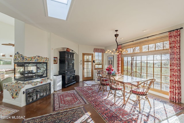 dining area with a skylight, dark wood-type flooring, and a chandelier