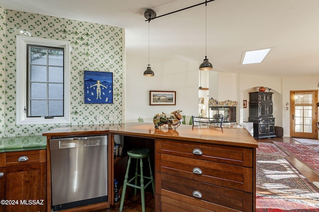 kitchen featuring hanging light fixtures, dishwasher, and a skylight