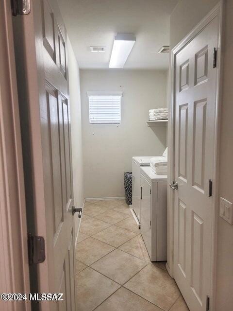 clothes washing area featuring washing machine and dryer and light tile patterned floors