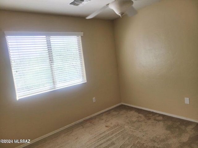 carpeted spare room with ceiling fan