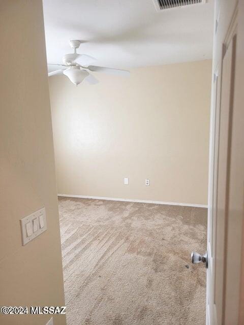 carpeted empty room featuring ceiling fan