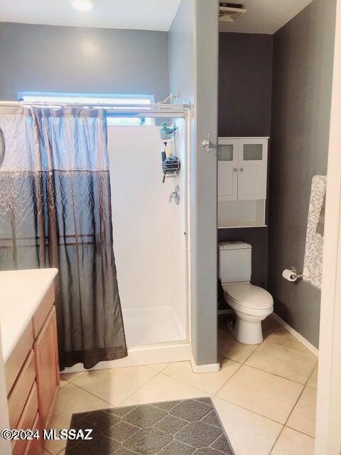 bathroom featuring vanity, a shower with curtain, toilet, and tile patterned flooring