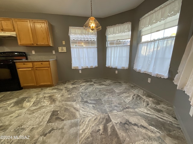 2655 W Desert Brook Ct, Tucson, AZ 85742 - kitchen with black range with electric cooktop, under cabinet range hood, hanging light fixtures, light countertops, and baseboards