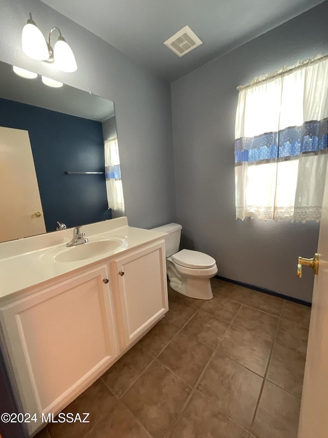 bathroom featuring tile patterned floors, vanity, and toilet