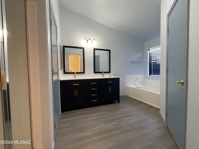 2655 W Desert Brook Ct, Tucson, AZ 85742 - full bathroom featuring vaulted ceiling, double vanity, a garden tub, wood finished floors, and baseboards