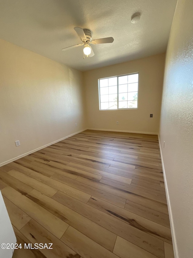 unfurnished room featuring a textured ceiling, light hardwood / wood-style floors, and ceiling fan