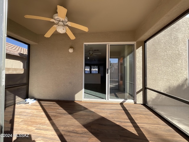 unfurnished sunroom with ceiling fan