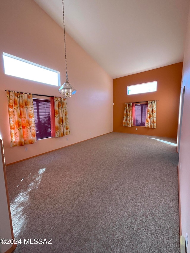 unfurnished living room with carpet flooring and high vaulted ceiling