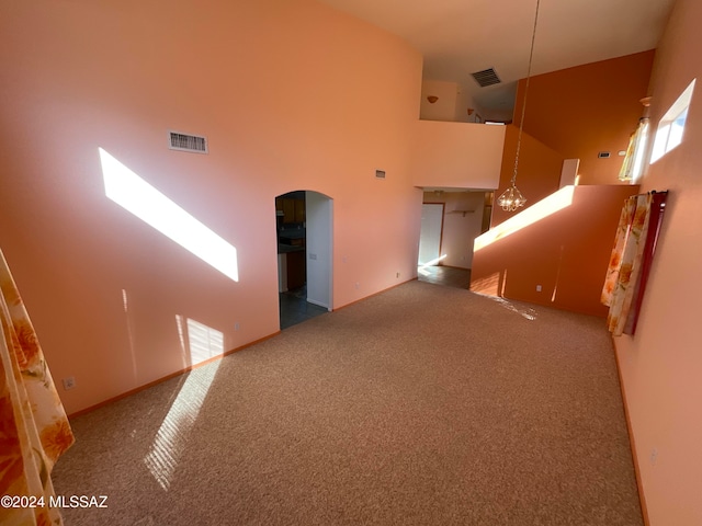 unfurnished room featuring a high ceiling and carpet flooring