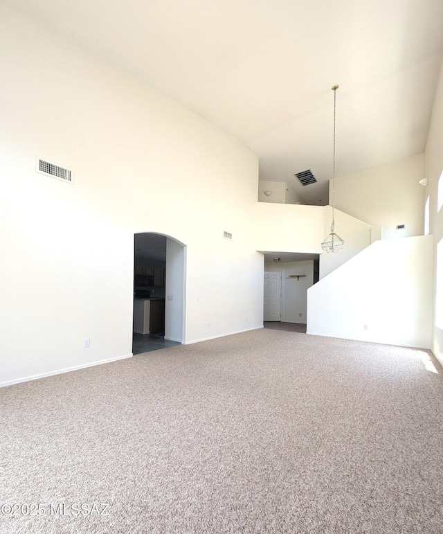 2655 W Desert Brook Ct, Tucson, AZ 85742 - unfurnished living room featuring a high ceiling, carpet, baseboards, and arched walkways