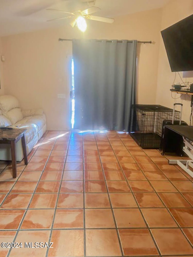 living room with tile patterned flooring, ceiling fan, and lofted ceiling