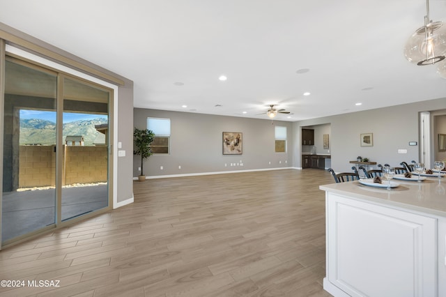 unfurnished living room with ceiling fan and light hardwood / wood-style floors